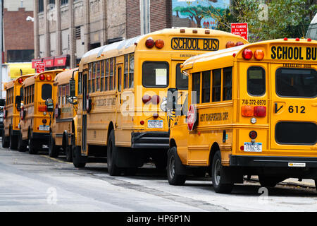 Una fila di American yellow scuolabus parcheggiato in una strada laterale nel cuore di Manhattan, New York Stati Uniti d'America Foto Stock