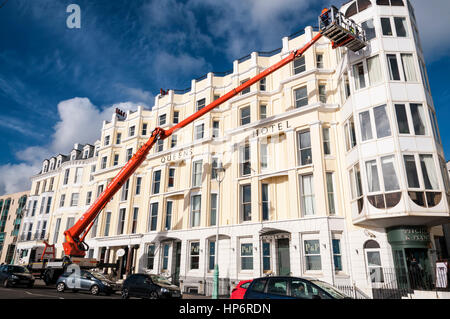 Una Palfinger 480 cherry picker essendo utilizzato per dare accesso per lavori di manutenzione, eventualmente per la pulizia dei vetri, su Queens Hotel, Brighton. Foto Stock