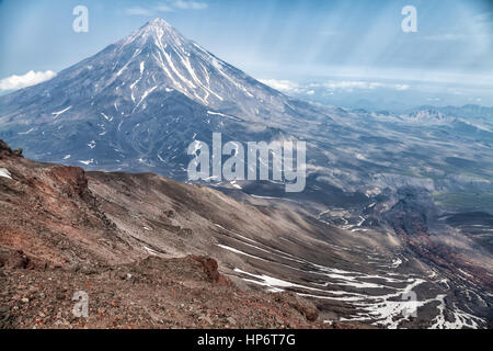 Montagne e vulcani. Lo splendido paesaggio della penisola di Kamchatka: estate vista panoramica della gamma della montagna Vachkazhets, lago di montagna e le nuvole in Foto Stock