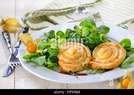 Cotta sostanziosa pasta sfoglia spuntini con salmone affumicato e crema di formaggio ed erbe fresche sulla lattuga agnelli Foto Stock