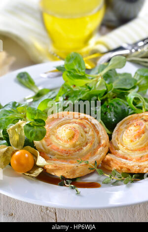 Cotta sostanziosa pasta sfoglia spuntini con salmone affumicato e crema di formaggio ed erbe fresche sulla lattuga agnelli Foto Stock