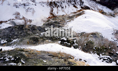 Primo piano in pietra la nebbia Noboribetsu Onsen neve invernale del parco nazionale di Jigokudani, Hokkaido, Giappone Foto Stock