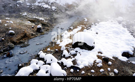 Primo piano della pietra e del flusso nella nebbia Noboribetsu Onsen neve invernale del parco nazionale di Jigokudani, Hokkaido, Giappone Foto Stock