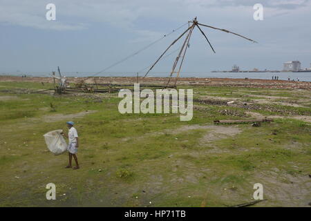 Kochi, India - 1 Novembre 2015 - uomo senza tetto la raccolta di rifiuti sulla spiaggia di Kochi, India Foto Stock