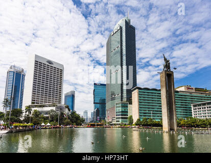 JAKARTA, Indonesia - 25 settembre 2016: alti edifici adibiti ad uffici e hotel di lusso edifici riflettono nell'acqua della fontana nel cuore di Jakart Foto Stock