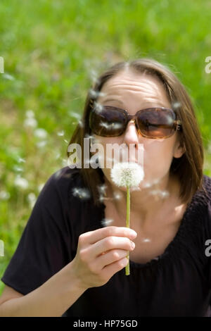 Modello rilasciato, Junge Frau mit Pusteblume - donna con blowball Foto Stock