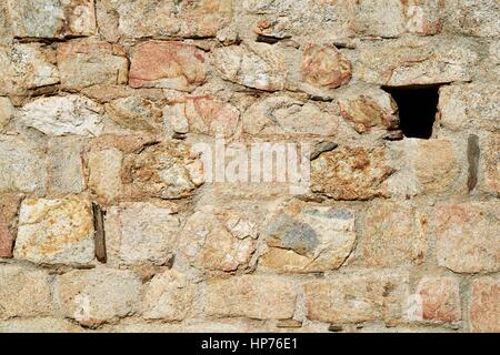 Sfondo di rosso e mattoni beige, uno mancante Foto Stock