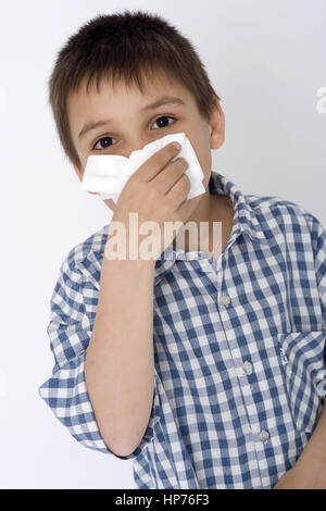 Modello rilasciato, Junge, 8, schneuzt sich - boy soffia il naso Foto Stock