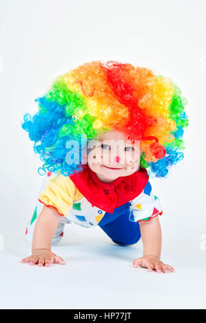 Bambino clown con un naso rosso multicolore in parrucca con sfere Foto Stock
