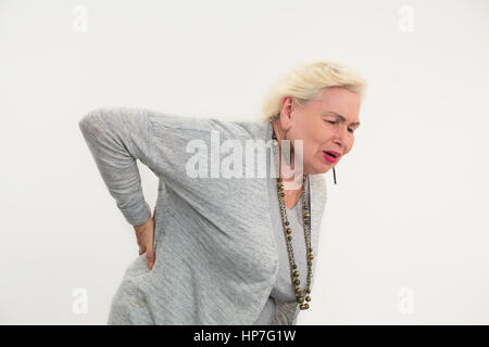 Senior donna avente un mal di schiena isolato. Signora toccando il suo indietro. Come curare lombalgia. Foto Stock