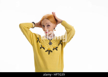 Donna che fissa i suoi capelli. Anziani femmina su sfondo bianco. Suggerimenti per apparire più giovani. Foto Stock