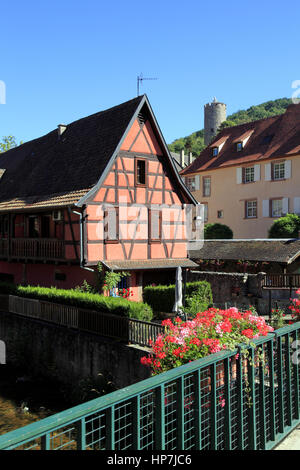 Maison à colombages dans le Centre du village sur les Rives de la Rivière Weiss et en fond le Château Impérial. Kaysersberg. F 68 Foto Stock