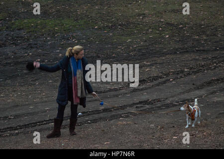 Una donna che cammina il suo cane nel parco centrale Foto Stock