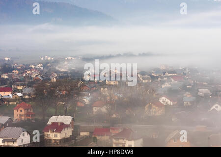 La nebbia di piccola città. Misty rurale scena. Mattinata nebbiosa nel villaggio. Foto Stock