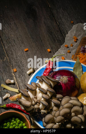 Ingredienti per la zuppa di verdure. verdure cetriolo cipolle patate carote funghi piselli spezie nella sezione sul grigio Sfondo di legno Foto Stock