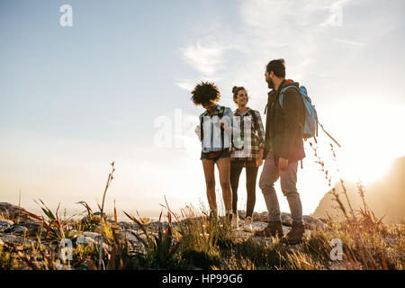 Gruppo di persone escursioni nella natura in un giorno di estate. Tre giovani amici su un paese a piedi. Foto Stock