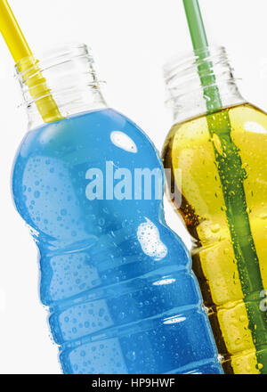 Zwei plastikflaschen mit farbigen energydrinks, strohhalme Foto Stock