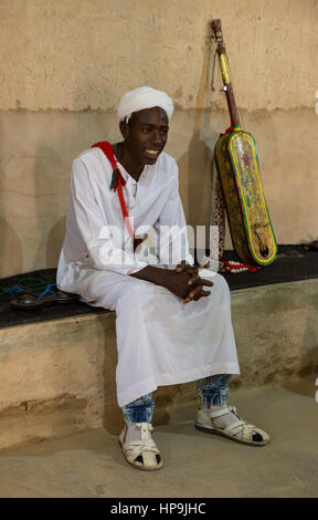 Merzouga, Marocco. Gnaoua musicista seduto accanto alla sua Gimbrie o Hajouj. Foto Stock