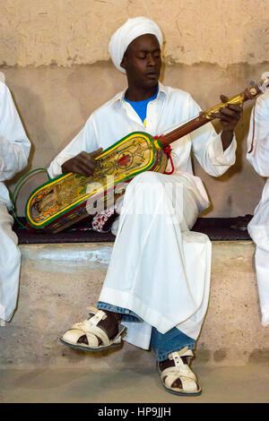 Merzouga, Marocco. Gnaoua musicista che gioca la sua Gimbrie o Hajouj. Foto Stock