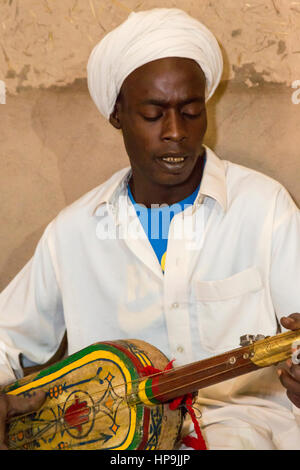 Merzouga, Marocco. Gnaoua musicista che gioca la sua Gimbrie o Hajouj. Foto Stock