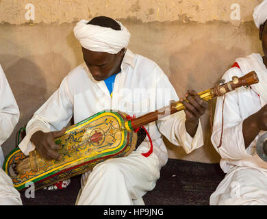 Merzouga, Marocco. Gnaoua musicista che gioca la sua Gimbrie o Hajouj. Foto Stock