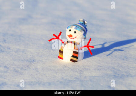 Pupazzo di neve sul bianco della neve. Luminosa sullo sfondo di Natale con pupazzo di neve. Pupazzo di neve su blured sfondo innevato. Foto Stock