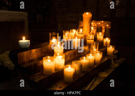 Candele accese in una chiesa Foto Stock