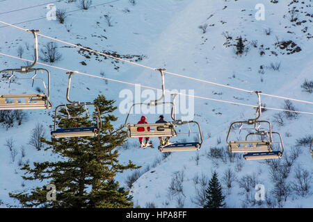 Gli sciatori su un impianto di risalita a Le Mont-Dore ski resort, massiccio del Sancy, Auvergne, Francia Foto Stock