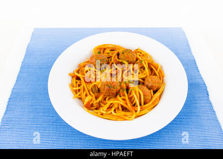 Home cotti sphagetti salato e polpette di carne, piastra bianca su un cartellone blu. Foto Stock
