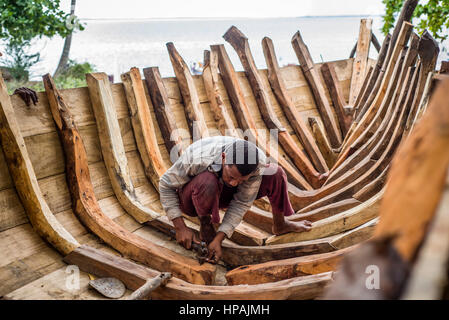 I carpentieri costruiscono una barca di legno nel villaggio di Mkokotoni, Zanzibar, Tanzania. Foto Stock