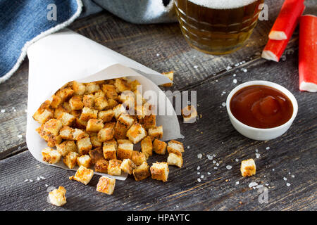 Gli snack. Crackers di granchio, essiccato il pane bianco e i bastoncini di granchio e il ketchup sul tavolo di legno. Foto Stock