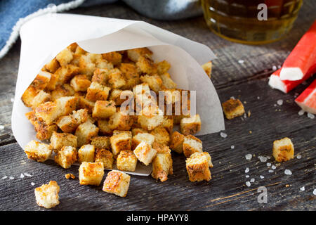 Gli snack. Crackers di granchio, essiccato il pane bianco e i bastoncini di granchio e il ketchup sul tavolo di legno. Foto Stock