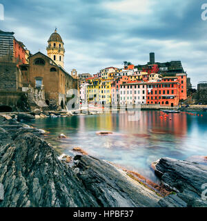 Vernazza village, chiesa, rocce e mare porto sul tramonto, Seascape in cinque terre, il Parco Nazionale delle Cinque Terre Liguria Italia Europa. Lunga esposizione. Foto Stock