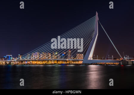 Il ponte di Erasmus attraverso il fiume Maas in Rotterdam durante le ore notturne con il towncenter illuminato in background. Foto Stock