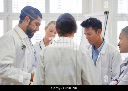 Interracial team di medici in riunione a discutere di diagnosticare al lavoro di squadra Foto Stock