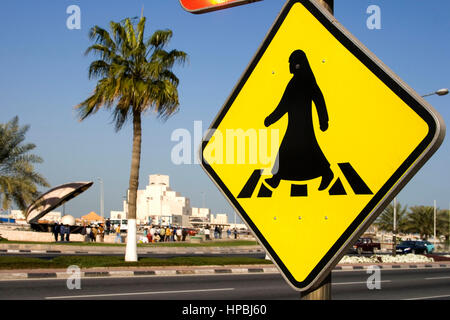 Il Qatar Doha arabian segno per crosswalk al corniche street , sullo sfondo il museo di arte islamica e la fontana di ostrica con perla lungo th Foto Stock