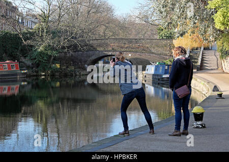 Un turista appoggiata a fotografare il ponte sulla strada della città bacino di Regents Canal a Islington, East London E1 Inghilterra UK KATHY DEWITT Foto Stock