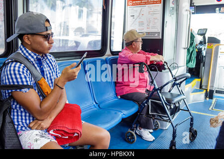Miami Beach Florida,Metrobus,South Beach locale,passeggeri passeggeri motociclisti,uomo ispanico uomini maschio,giovane adulto,anziani cittadini,Sit Foto Stock