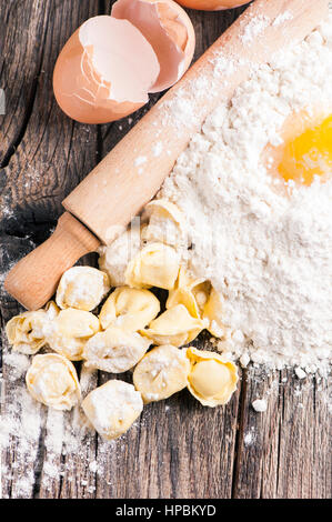 Materie tortellini su tavola in legno rustico Foto Stock