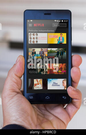 Close-up di mano d'uomo cella di contenimento con Netflix Application sullo schermo ((solo uso editoriale<) Foto Stock