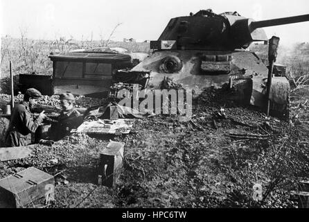 La propaganda nazista immagine mostra la Wehrmacht tedesca soldati in un bunker di terra nella parte anteriore di un distrutto T-34 serbatoio sovietica a Stalingrado (oggi Volgograd). Presa nel novembre 1942. Un nazista reporter ha scritto sul retro della foto su 26.11.1942, "La lotta per Stalingrado. Un burn-out T 34 utilizzati per la protezione contro le bombe e le schegge per un tedesco bunker di terra." Foto: Berliner Verlag / Archivio - nessun filo - SERVIZIO | Utilizzo di tutto il mondo Foto Stock