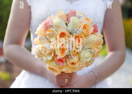Sposa con matrimonio bouquet di rose all'aperto Foto Stock