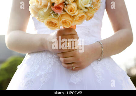 Sposa con matrimonio bouquet di rose all'aperto Foto Stock