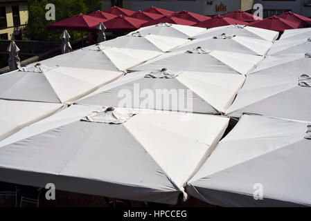 Ristorante a Potes, Picos de Europa, Cantabria, Spagna, con il rosso e bianco di ombrelloni Foto Stock