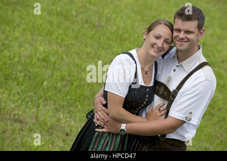 Modello rilasciato , Junges Paar in Tracht in der Wiese - coppia giovane in costume tradizionale Foto Stock