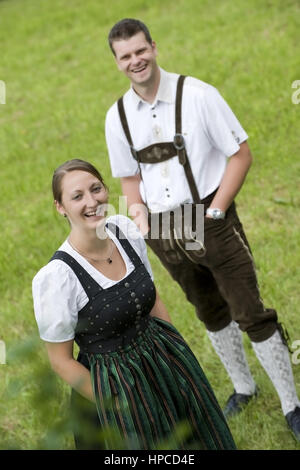 Modello rilasciato , Junges Paar in Tracht in der Wiese - coppia giovane in costume tradizionale Foto Stock