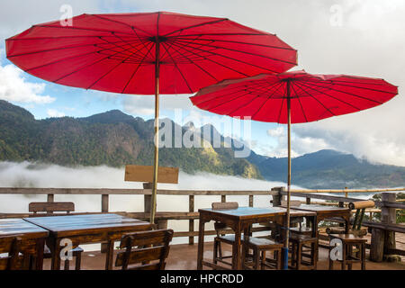 Bella outdoor cafe con tradizionale tailandese rossa ombrelloni nel nord della Thailandia. Foto Stock