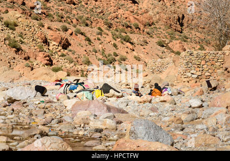 Tinghir, Marocco - Jan 05, 2017: donne marocchine il lavaggio della biancheria nel fiume ed essiccato su rocce. Todgha Gorge è canyon in montagne Atlas, vicino a T Foto Stock