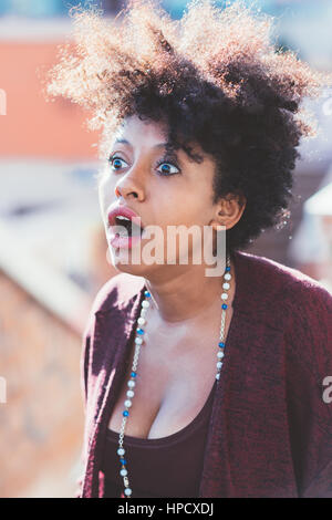 Ritratto di giovane bella afro nero donna guarda stupito - sorpreso, espressione facciale, scioccato concept Foto Stock