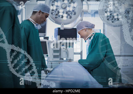 Vista panoramica del modello di helix informazioni sulla schermata del dispositivo contro i chirurghi di eseguire l'operazione nel teatro di funzionamento Foto Stock